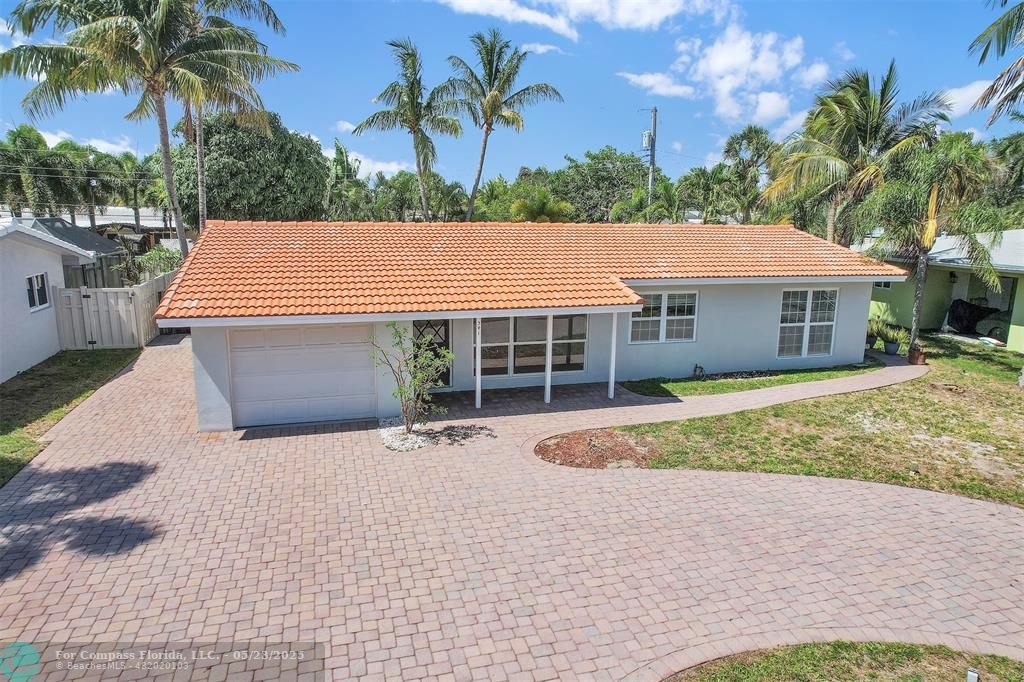 341 Southeast 8th Street Pompano Beach, FL 33060 - Photo 32 of 56 a front view of a house with a garden and trees