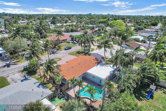 an aerial view of residential houses with outdoor space and trees
