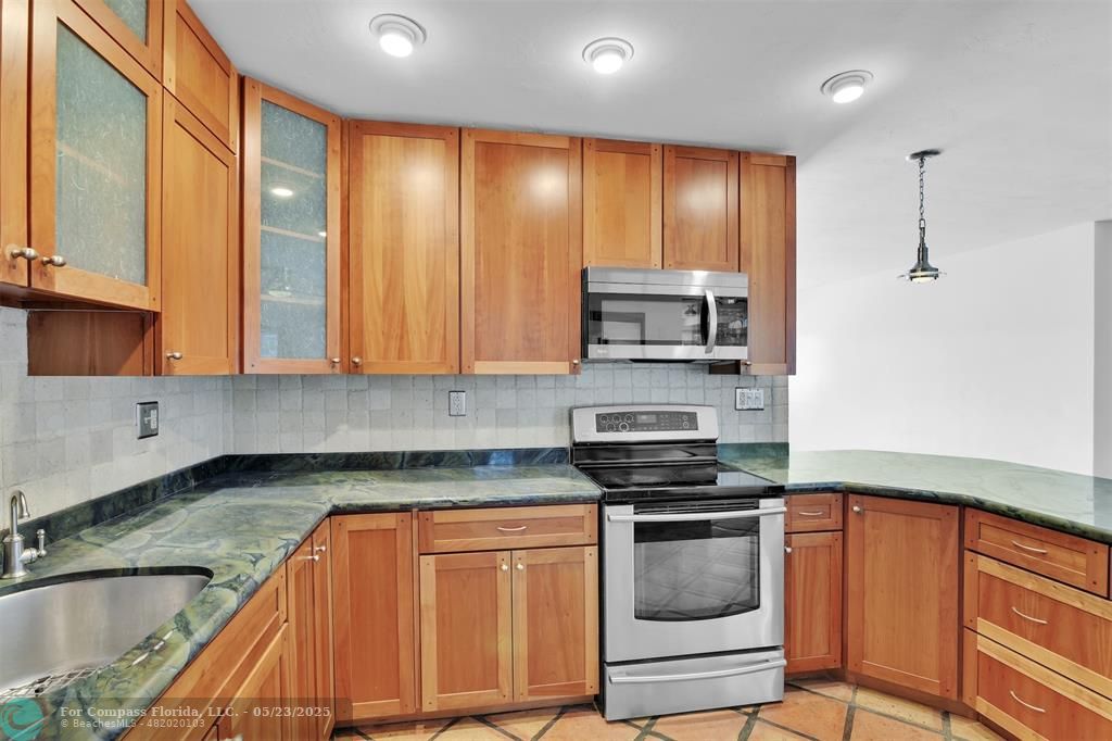341 Southeast 8th Street Pompano Beach, FL 33060 - Photo 5 of 56 a kitchen with stainless steel appliances granite countertop a stove and a sink