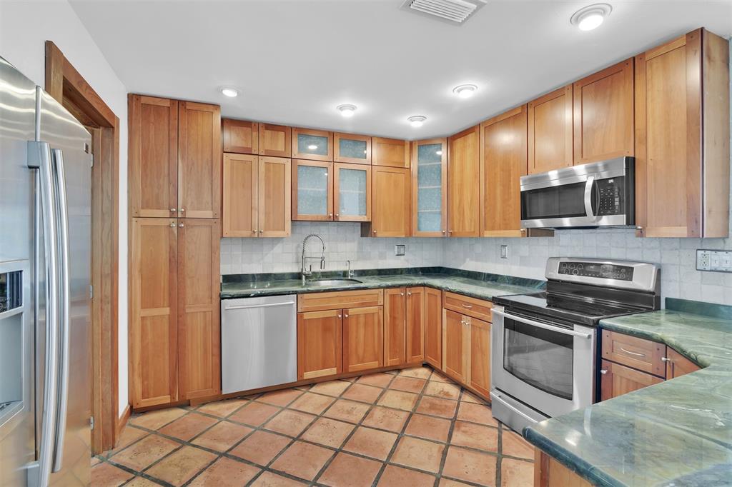 341 Southeast 8th Street Pompano Beach, FL 33060 - Photo 6 of 56 a kitchen with stainless steel appliances granite countertop a refrigerator and a stove top oven