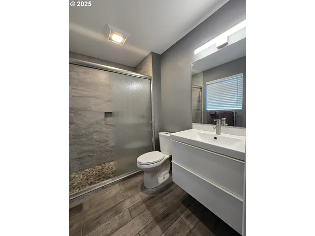 a bathroom with a sink a toilet and shower