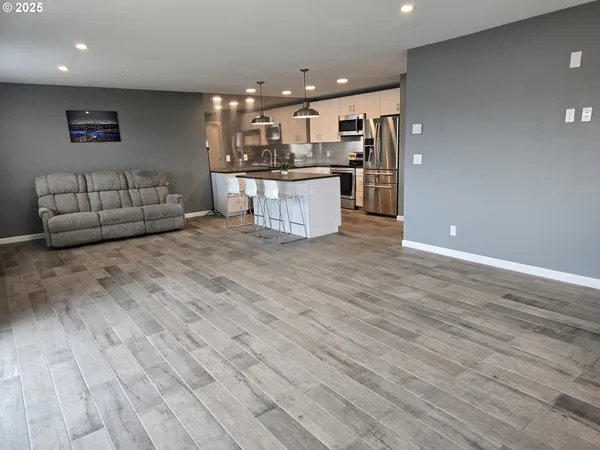 a kitchen with stainless steel appliances kitchen island granite countertop a stove and a wooden floors