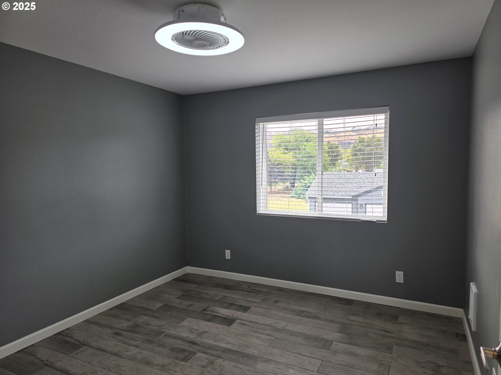 260 Lone Pine Lane, Unit 2 The Dalles, OR 97058 - Photo 10 of 23 an empty room with wooden floor and windows