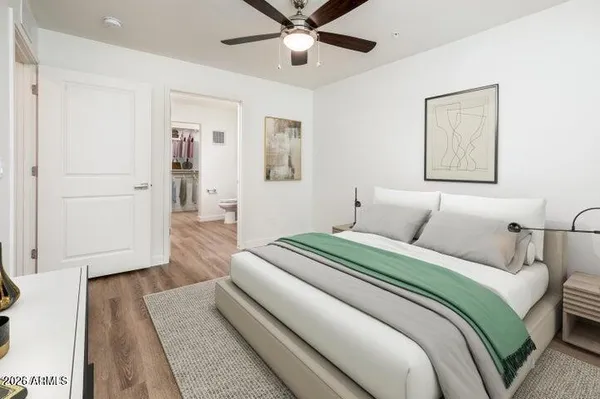 a bedroom with a large bed and a ceiling fan