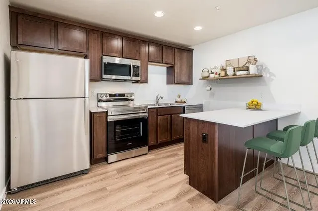 a kitchen with stainless steel appliances a stove a sink and a refrigerator