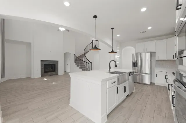 a large kitchen with white cabinets and stainless steel appliances