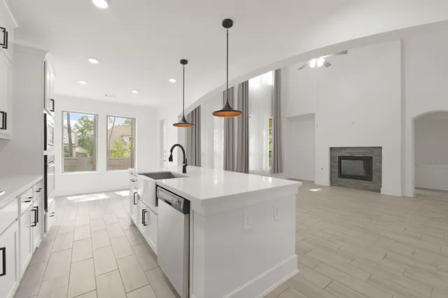 a large kitchen with stainless steel appliances a sink stove and cabinets