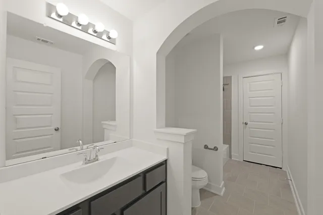 a bathroom with a toilet a sink and mirror