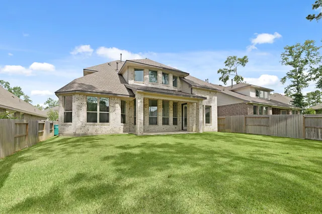 a view of a house with a big yard and large trees