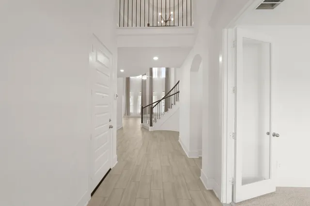 a view of a hallway with wooden floor and staircase