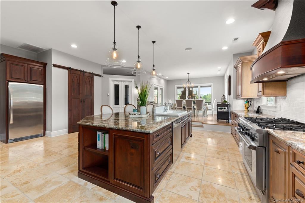 65 Waterhill Way Fletcher, NC 28732 - Photo 20 of 48 a kitchen with stainless steel appliances granite countertop a stove a sink dishwasher a refrigerator and a dining table with wooden floor