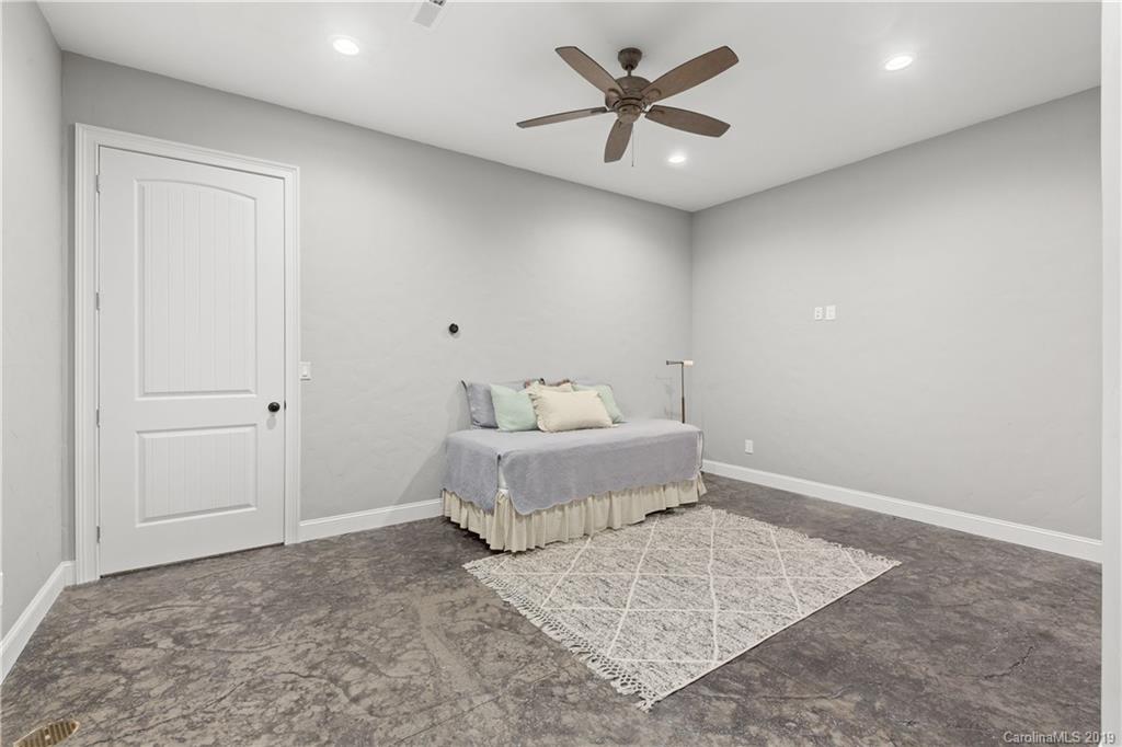65 Waterhill Way Fletcher, NC 28732 - Photo 44 of 48 a spacious bedroom with a bed and a chandelier
