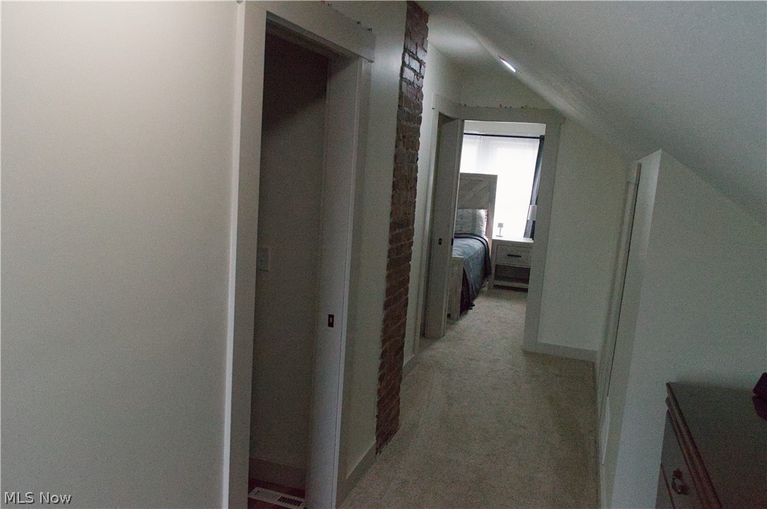 3187 Grenfall Road Barberton, OH 44203 - Photo 11 of 17 This hallway features exposed brickwork, a carpeted floor, and white walls