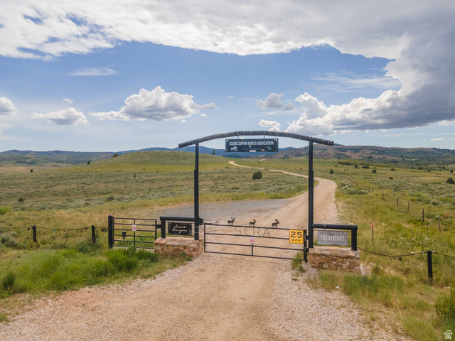 23 Scare Canyon, Unit 23 Logan, UT 84321 - Photo 6 of 33 Gated entry to Black Canyon Ranch Association featuring a gravel driveway, stone pillars, and surrounding natural landscape