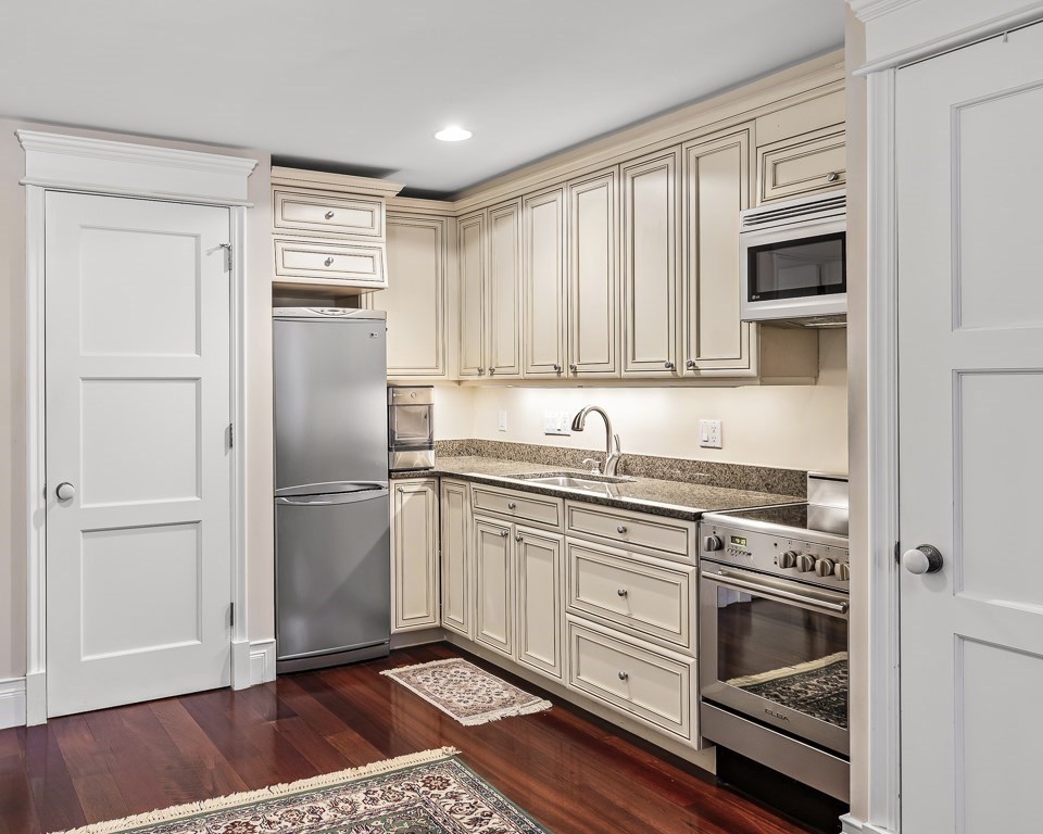 a kitchen with granite countertop a refrigerator stove and microwave