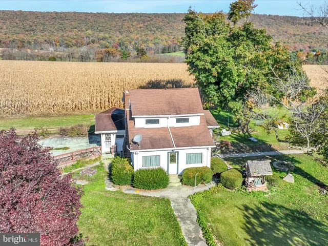 an aerial view of house with yard and ocean view