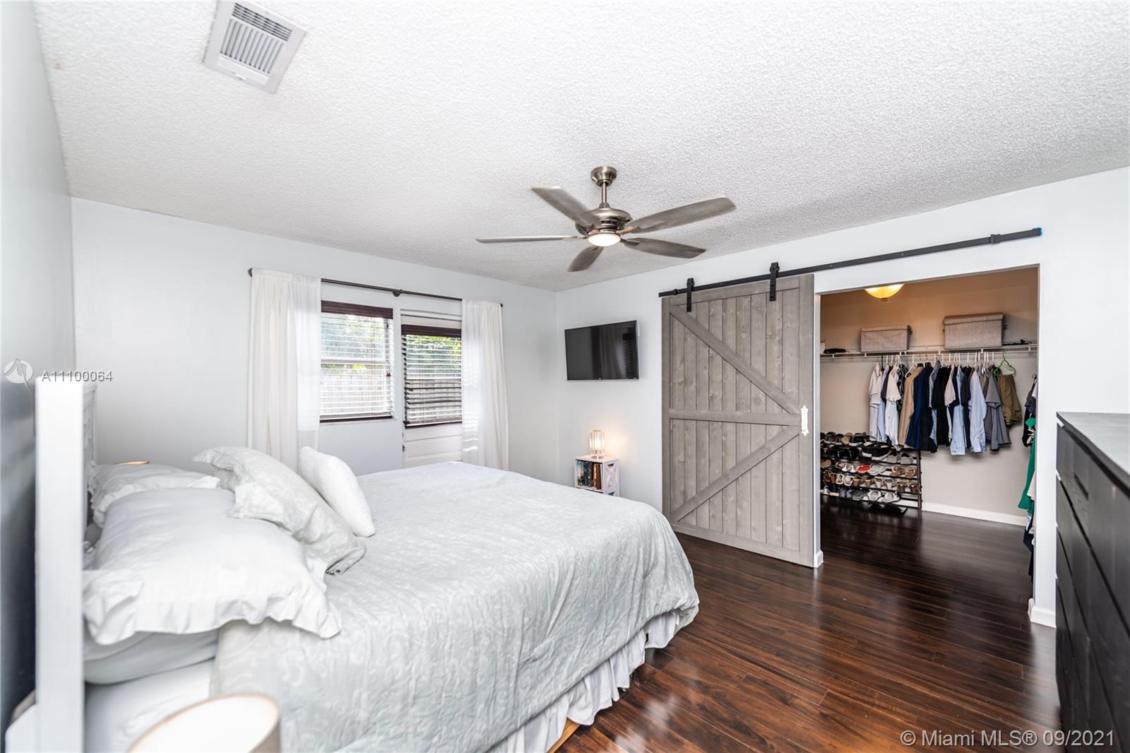 8854 Southwest 11th Street Boca Raton, FL 33433 - Photo 14 of 99 a bedroom with a large bed and a wooden floor