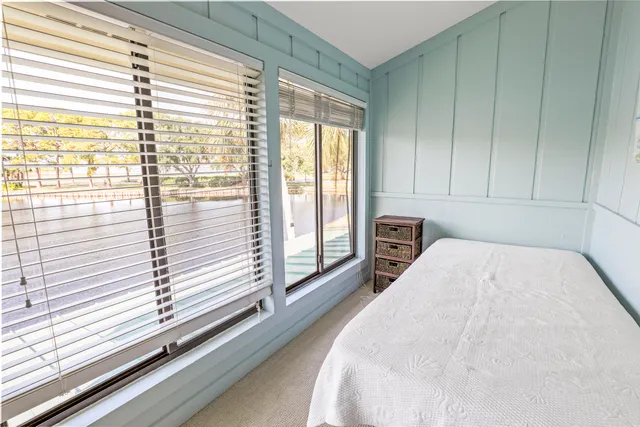 a bedroom with a bed and a large window
