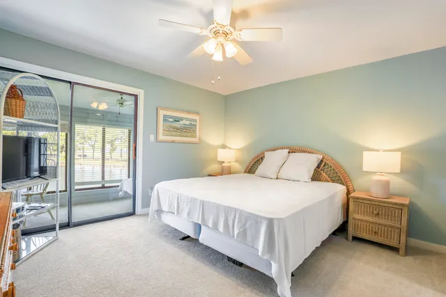 a bedroom with a large bed and a chandelier fan