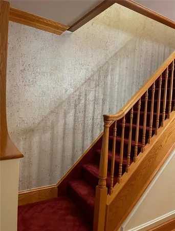 a view of staircase with wooden floor and white walls