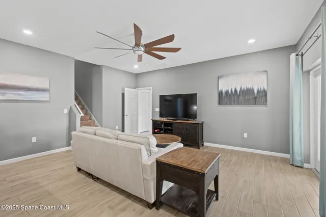 a living room with furniture and a wooden floor