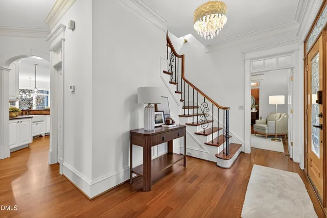 a dining room with furniture a chandelier and wooden floor