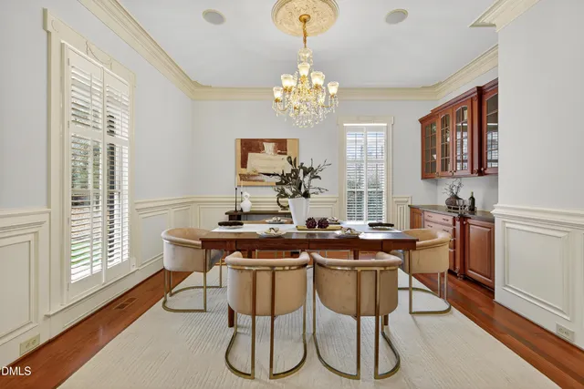 a kitchen with stainless steel appliances granite countertop a stove a sink and white cabinets with wooden floor