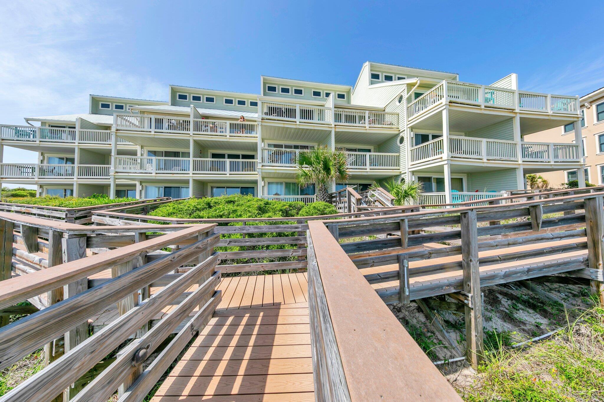8294 East County Highway 30A, Unit 1 Inlet Beach, FL 32461 - Photo 30 of 45 a front view of a building with a garden and seating area