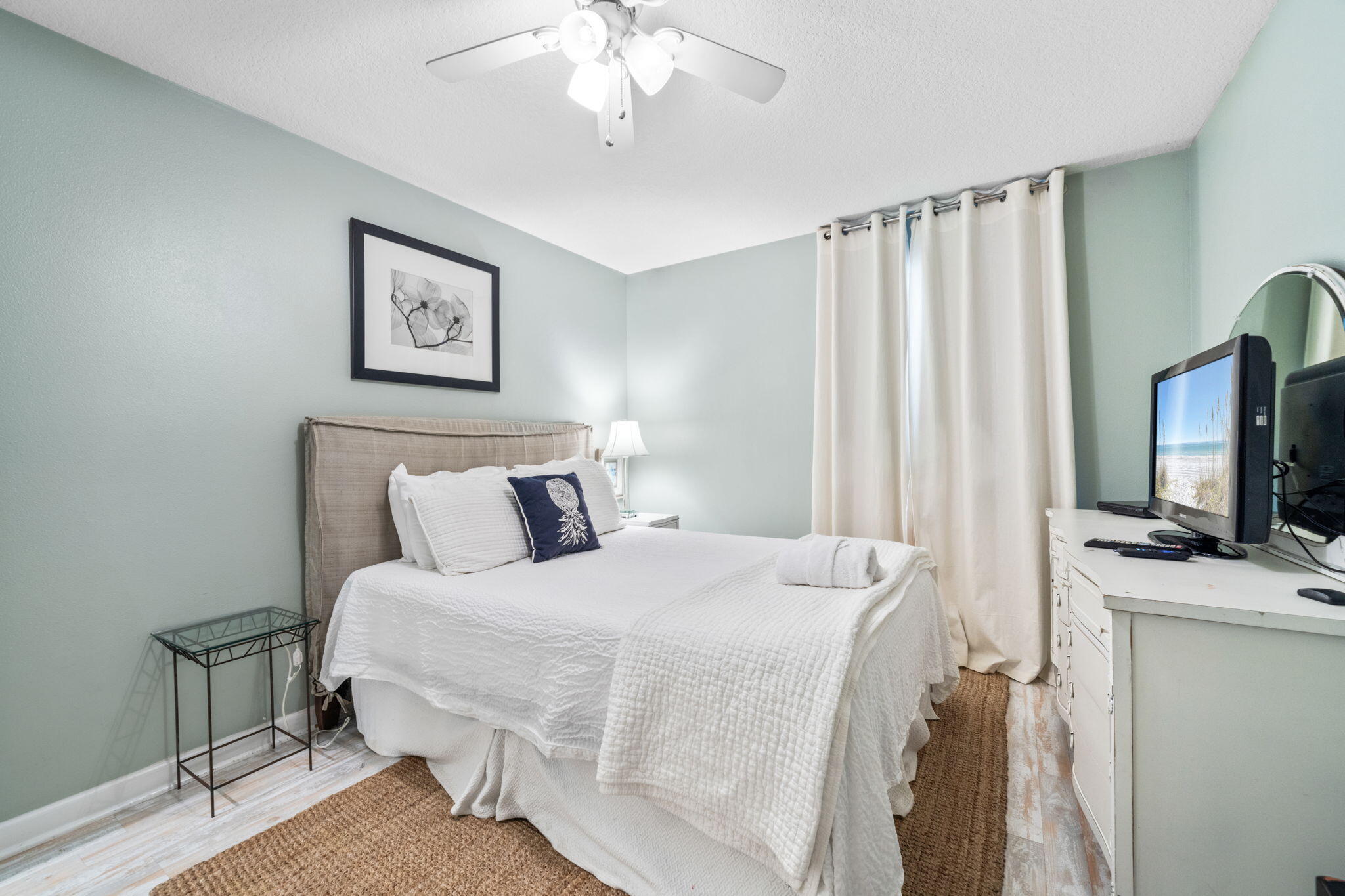 8294 East County Highway 30A, Unit 1 Inlet Beach, FL 32461 - Photo 4 of 45 a bedroom with a bed a flat screen tv and a chandelier