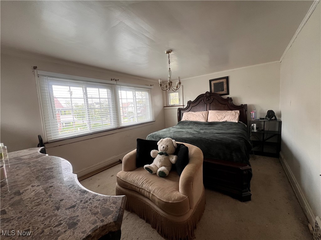 1686 Avalon Road Cleveland, OH 44112 - Photo 15 of 22 Bedroom featuring crown molding, baseboards, a chandelier, and light colored carpet