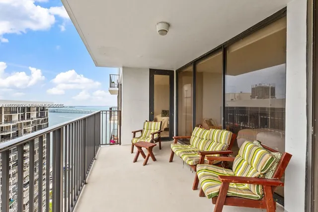 a balcony with couple of chairs and couch