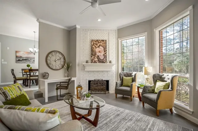 a living room with fireplace furniture and a large window