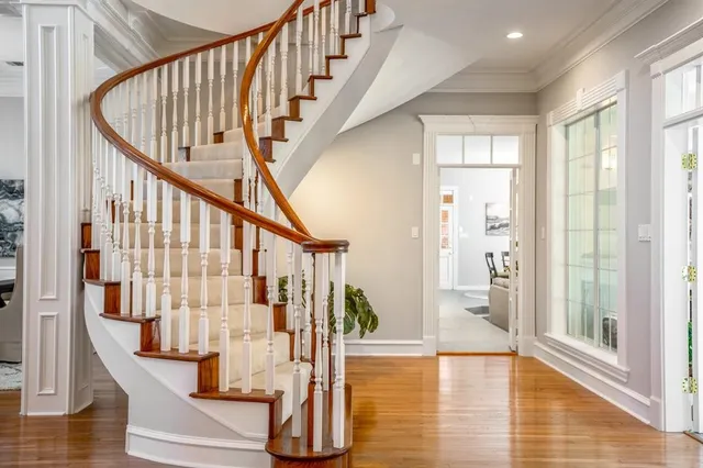 a view of staircase with lots of frames on wall and wooden floor