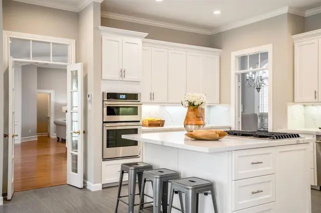 a kitchen with a refrigerator and white cabinets