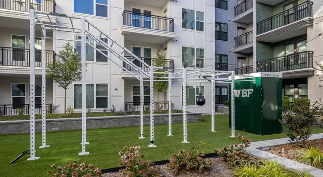 a backyard of a multi story building with yard and outdoor seating