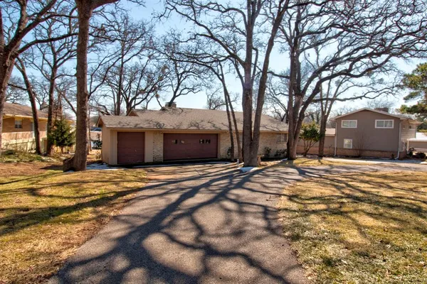 a front view of a building with a yard and trees