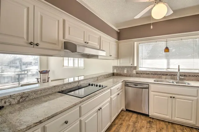 a kitchen with white cabinets and a window