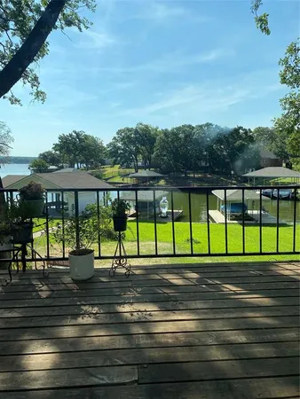 a view of a house with a yard and large tree