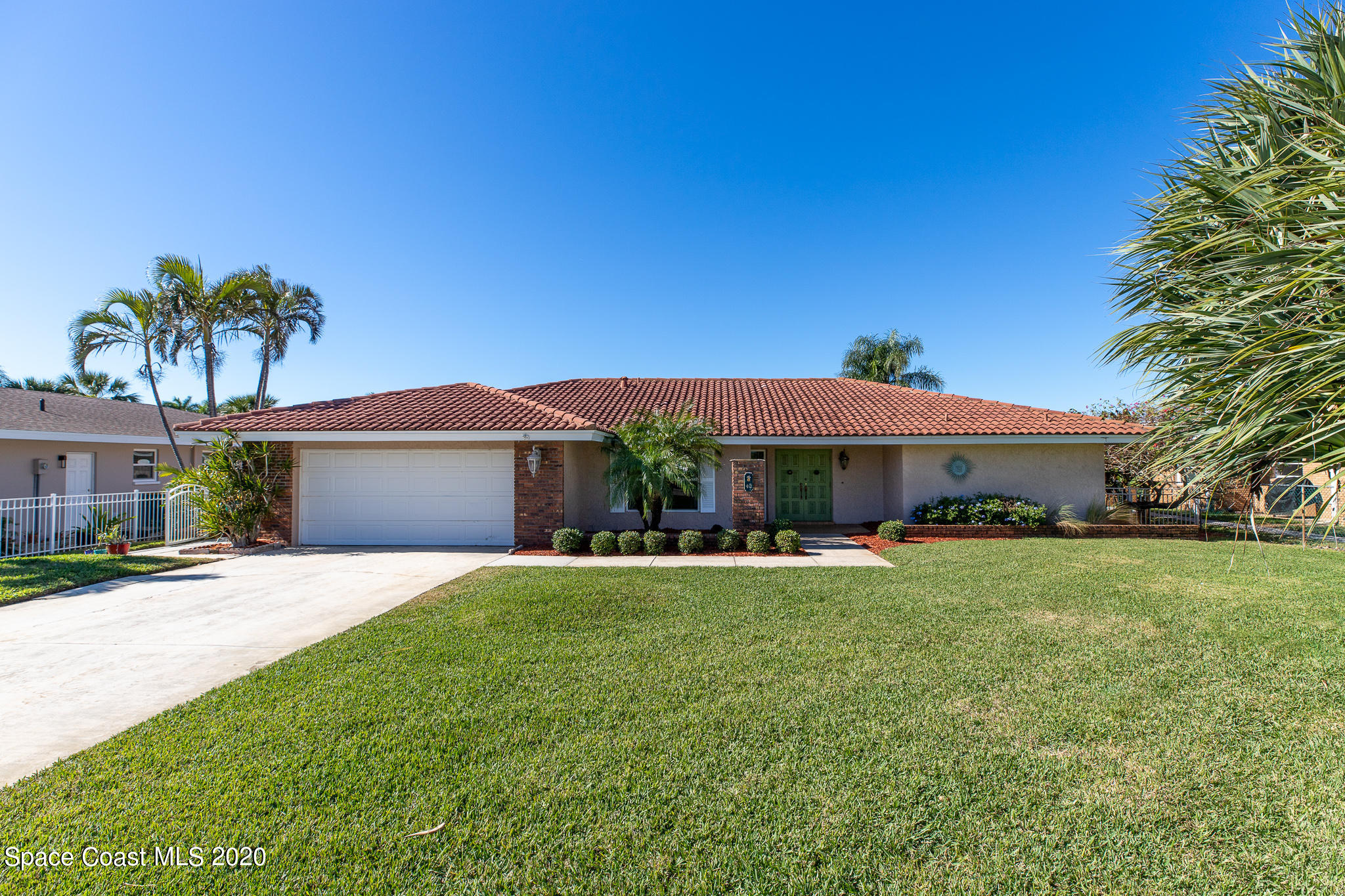43 Country Club Road Cocoa Beach, FL 32931 - Photo 2 of 35 a front view of a house with a garden