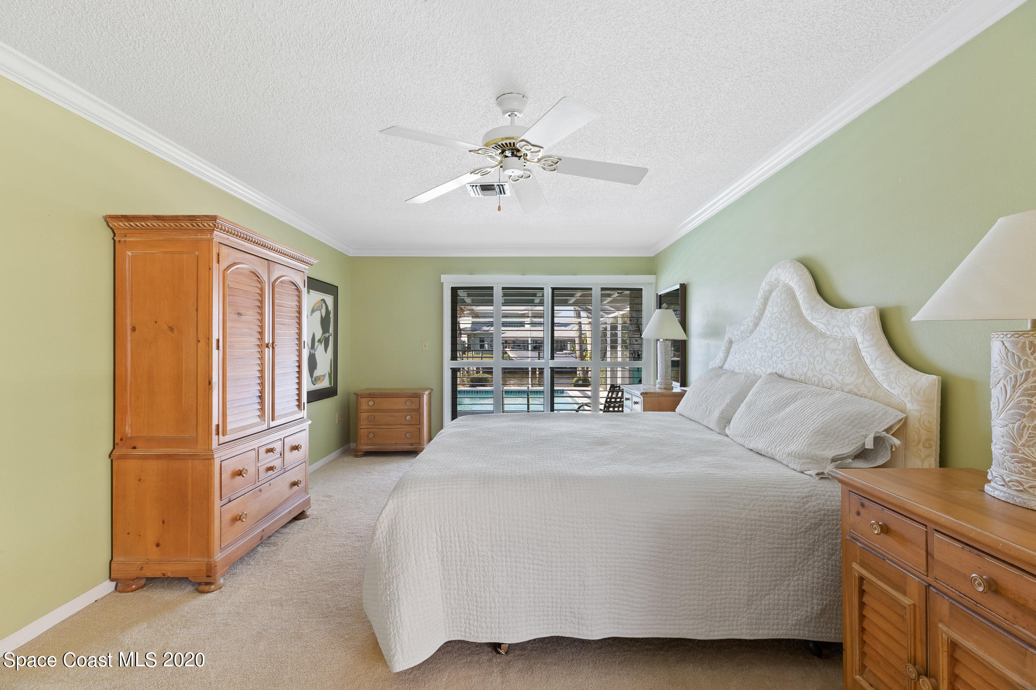 43 Country Club Road Cocoa Beach, FL 32931 - Photo 19 of 35 a bedroom with a large bed and a chandelier