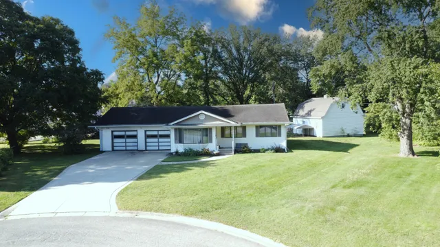 a view of a house with a yard and large tree