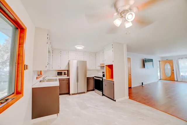 a view of a kitchen with furniture and stainless steel appliances