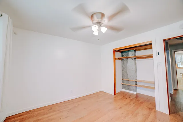 a view of a room with wooden floor closet and windows