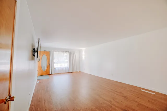a view of a room with wooden floor and a window