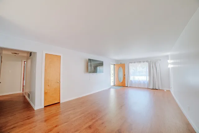a window in an empty room with wooden floor