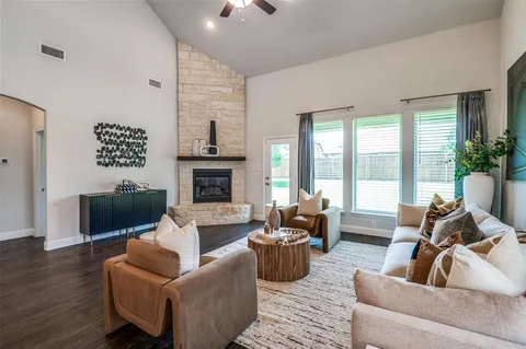 a living room with furniture fireplace and a large window