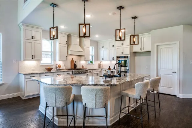 a dining room with stainless steel appliances kitchen island granite countertop a dining table chairs and a refrigerator