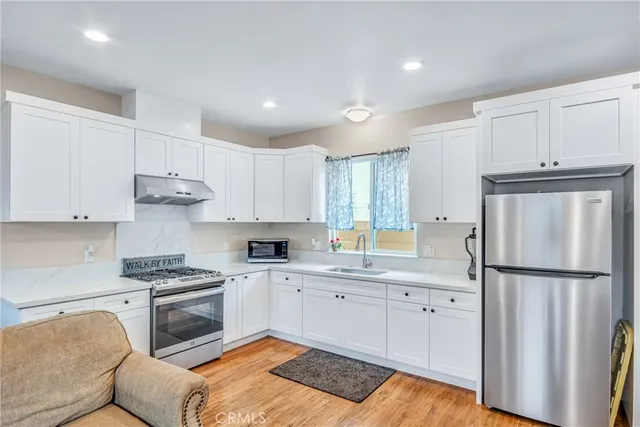 a kitchen with white cabinets and stainless steel appliances