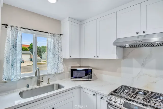 a kitchen with granite countertop a sink stainless steel appliances and cabinets