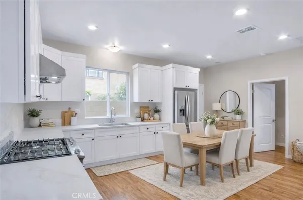 a kitchen with a dining table chairs and white cabinets